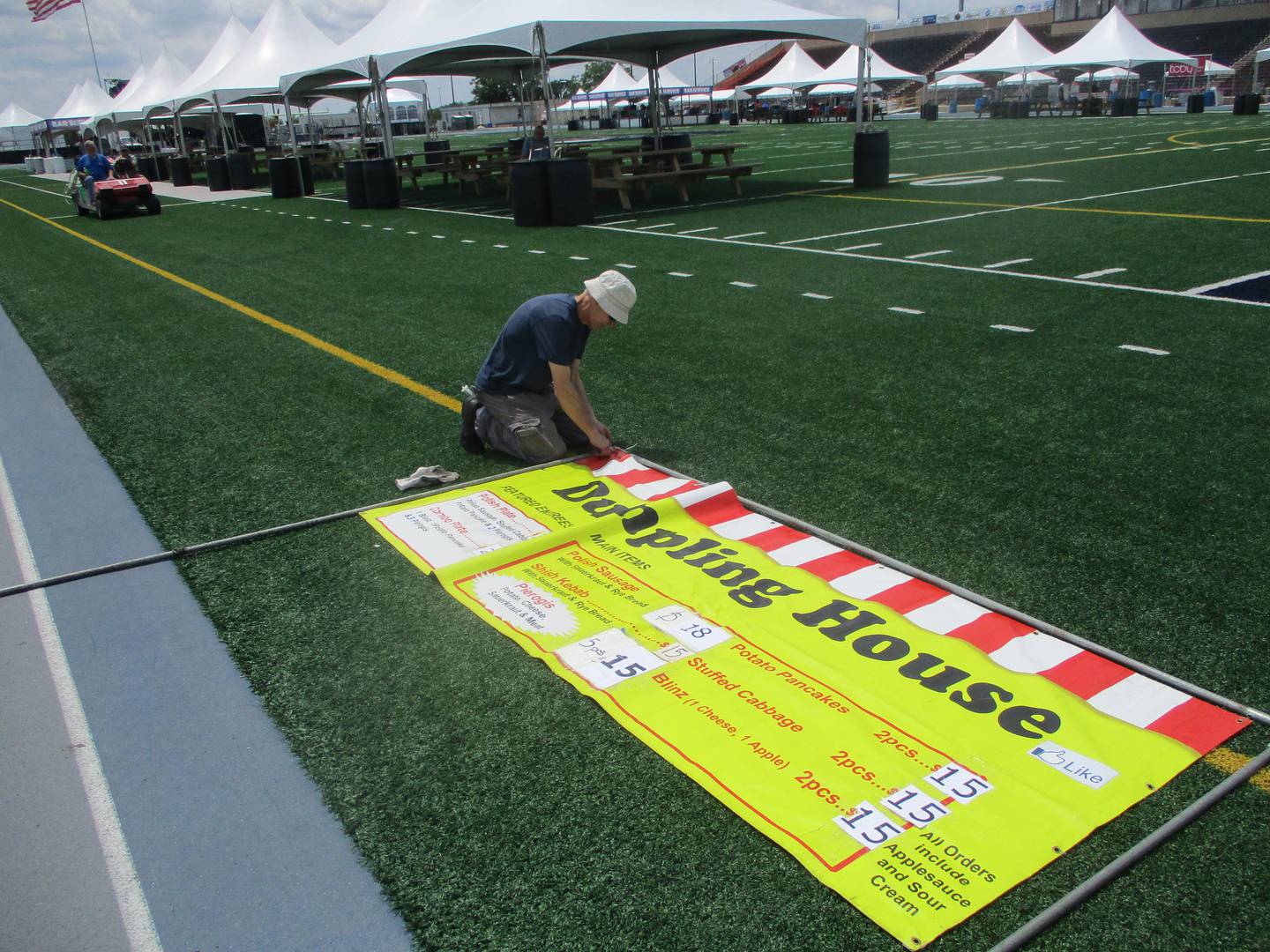 An employee for the Dumpling House prepares a sign on Thursday for the Taste of Joliet. June 19, 2025