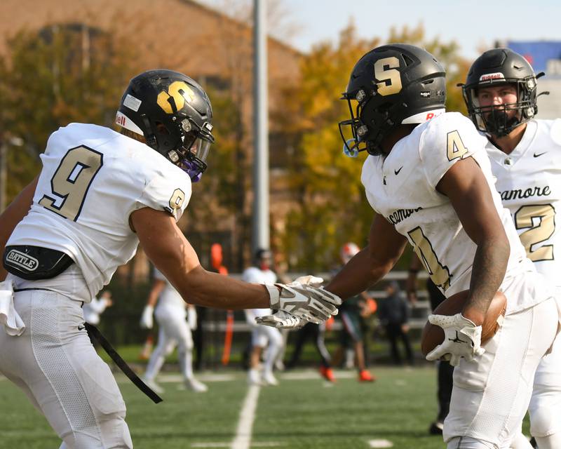 Sycamore Tyler Curtis (4) gets congratulated by teammate Miles Galindo (9) after getting an interception in the second quarter on Saturday Nov. 4, 2023, while taking on Morgan Park at Gately Stadium in Chicago.