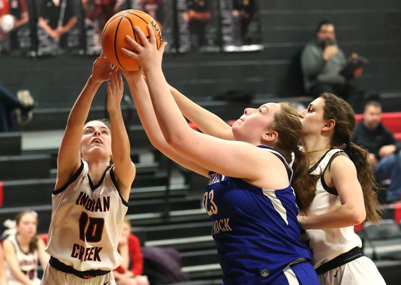 Hinckley-Big Rock's Sami Carlino grabs a rebound between Indian Creek's Ally Keilman (left) and Isabella Turner during their game Monday, Jan. 13, 2025, at Indian Creek High School in Shabbona.