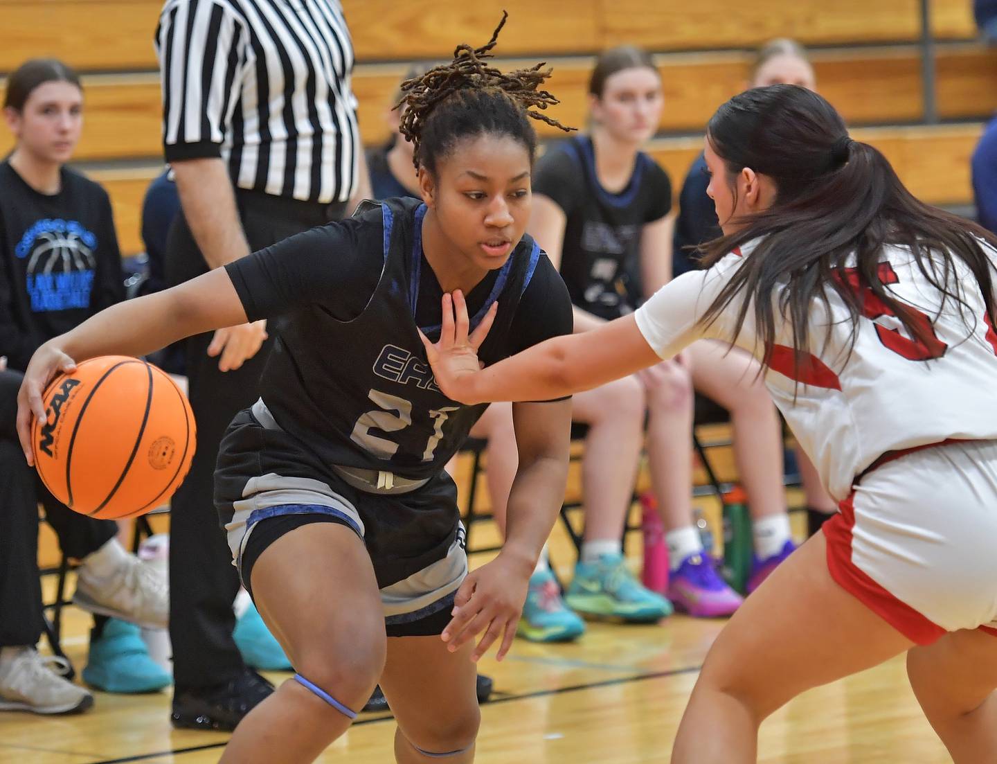 Oswego East’s Desiree Merritt drives as Benet’s Ava Thomas (right) defends during the Class 4A Benet Regional final on February 19, 2026 at Benet Academy in Lisle.