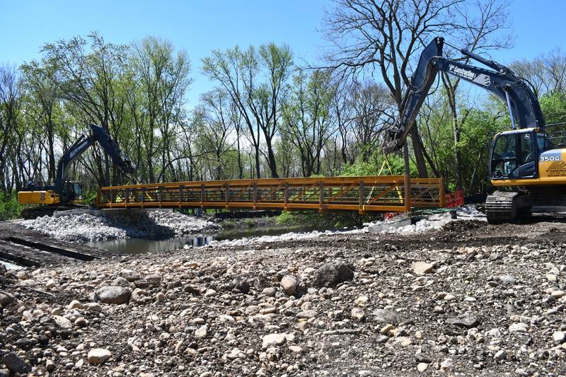 Construction vehicles installing the 90-foot bridge over the canal at Chaminwood Lake in Channahon on April 19.