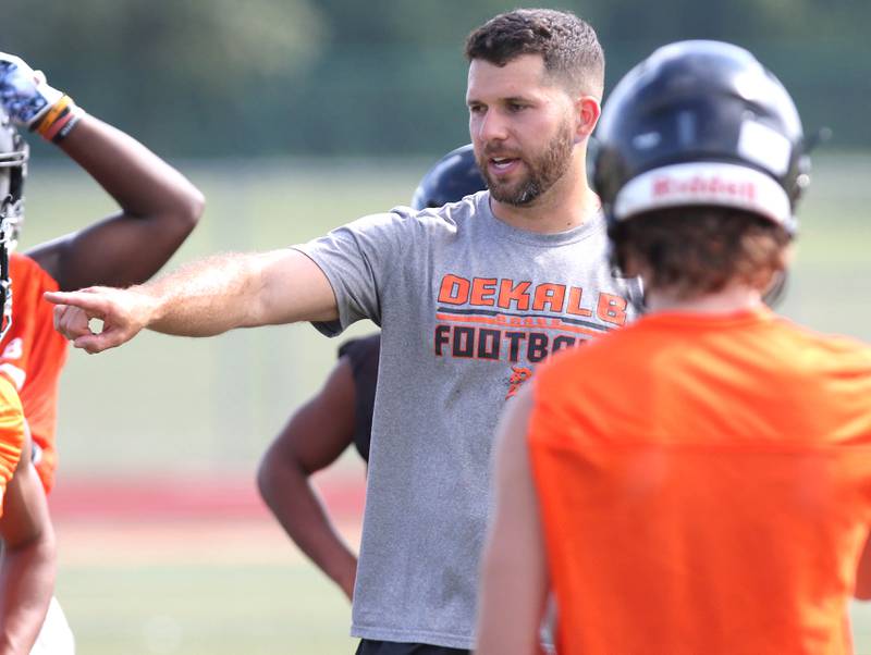 DeKalb Head Coach Derek Schneeman instructs his team Monday, Aug. 7, 2023, at DeKalb High School.