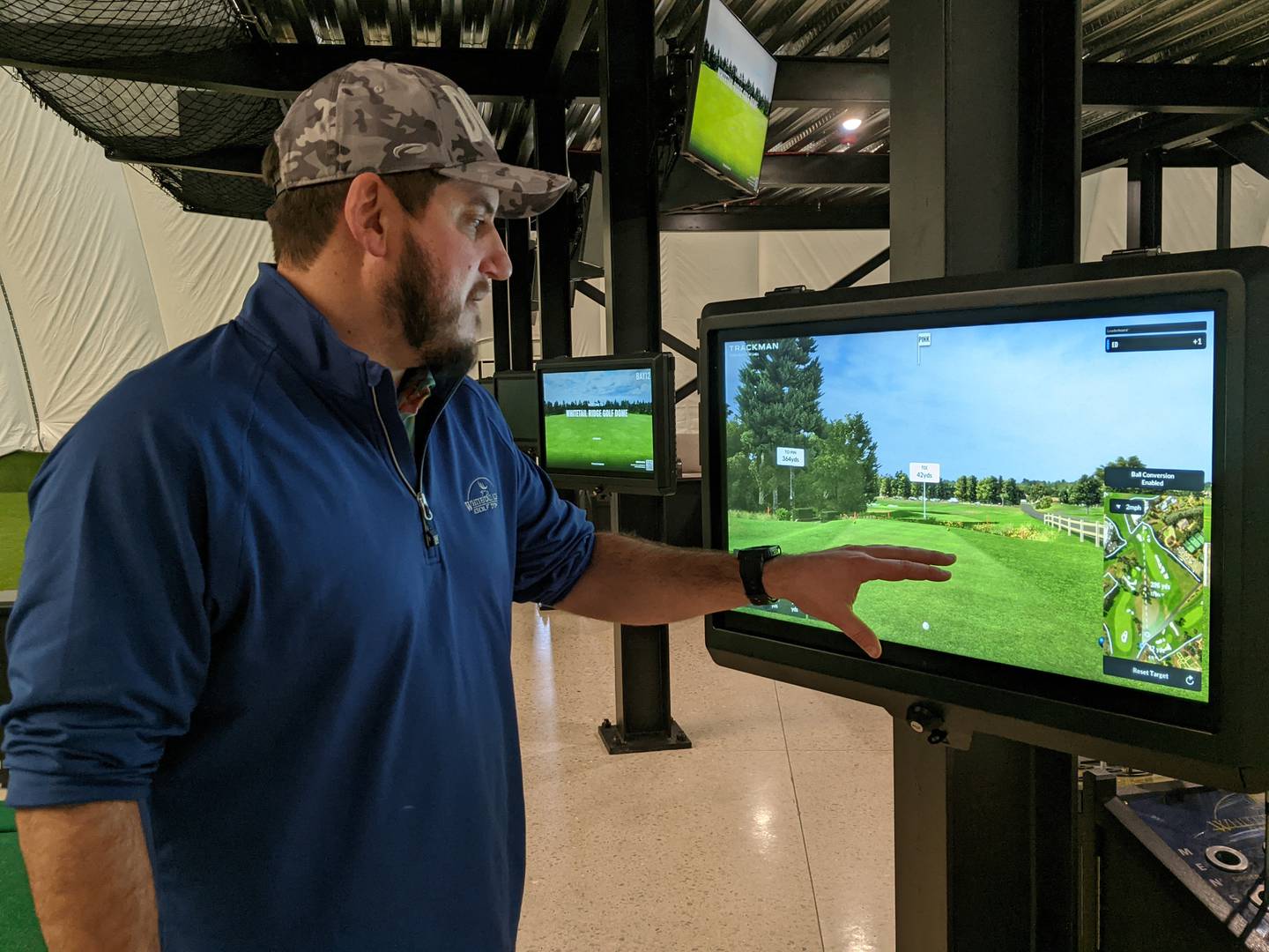 Alex Balog, director of golf operations for Yorkville-based Whitetail Ridge Golf Club, demonstrates how one can simulate playing on different golf courses while playing at Whitetail Ridge Golf Dome in Oswego.