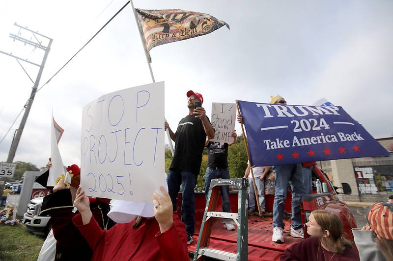 Trump supporters yell as they counter protest from the bed of a pickup truck during a "No Kings” protest rally on Saturday, Oct. 18, 2025, along Route 31 in McHenry. The protest drew thousands of protesters to the area to protest the policies of President Donald Trump.