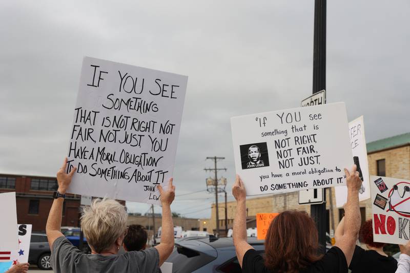 Protesters hold signs in reference to the late civil rights leader and congressman John Lewis during a "Good Trouble Lives On" rally held in Kankakee as part of a national day of peaceful protests on Thursday, July 17, 2025.