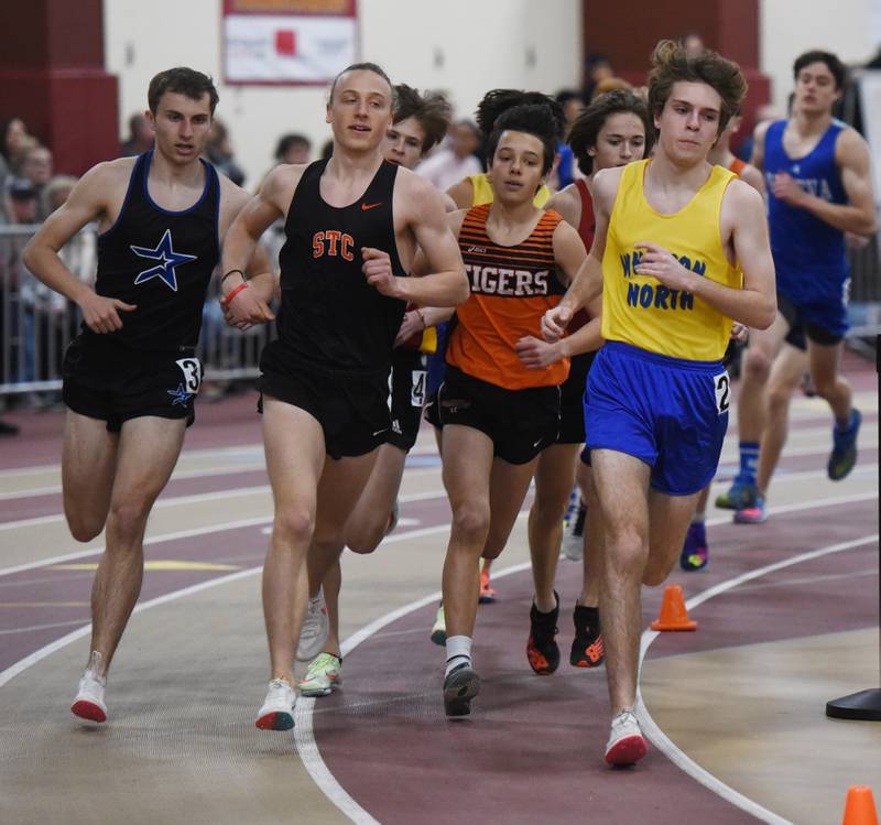 Runners are tightly bunched early in the 3,200-meter run during the DuKane boys indoor track meet at Batavia High School Saturday. St. Charles East’s Micah Wilson, second from left, won the event with a time of 10:04.26.