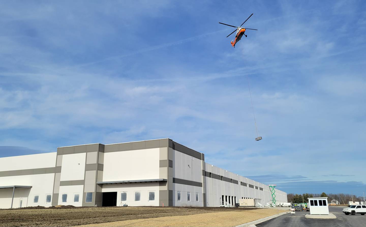 A 1962 Sikorsky helicopter lifts one of 10 heating and air conditioning units onto the roof of the new Ollie’s Bargain Outlet warehouse near the intersection of Interstate 80 and Illinois Route 26 in Princeton on Friday morning. The helicopter, according to an employee of Midwest Helicopters in Willowbrook, has a maximum lifting capacity of 5,000 pounds, so it managed to handle with ease the units that ranged in weight from 1,000 to 2,500 pounds in less than half an hour.