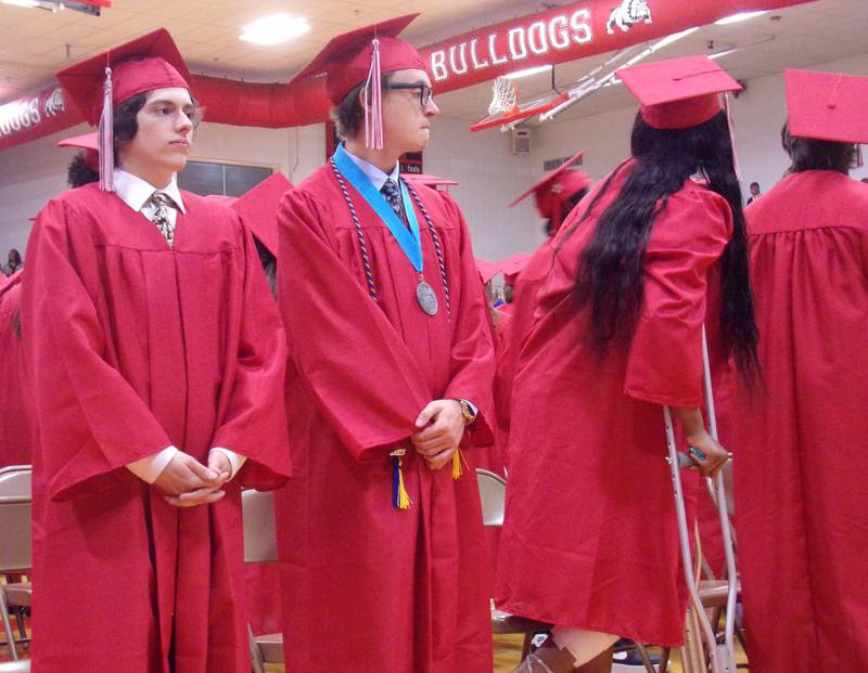 Graduating seniors Nicholas Adams and Connor Akin stand and wait as the rest of the Streator High School Class of 2023 takes their seats at the beginning of the graduation ceremony Sunday, May 21, 2023, at Pops Dale Gymnasium.
