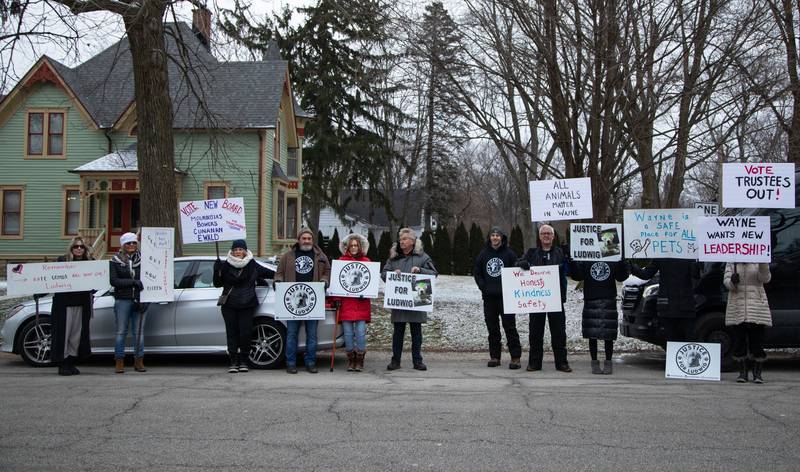 Justice for Ludwig protesters pose for a photo outside the Little Home Church by the Wayside in Wayne on Saturday, Jan. 7, 2023. Inside the church a town hall meeting took place to discuss an architectural review of the village hall and police department.