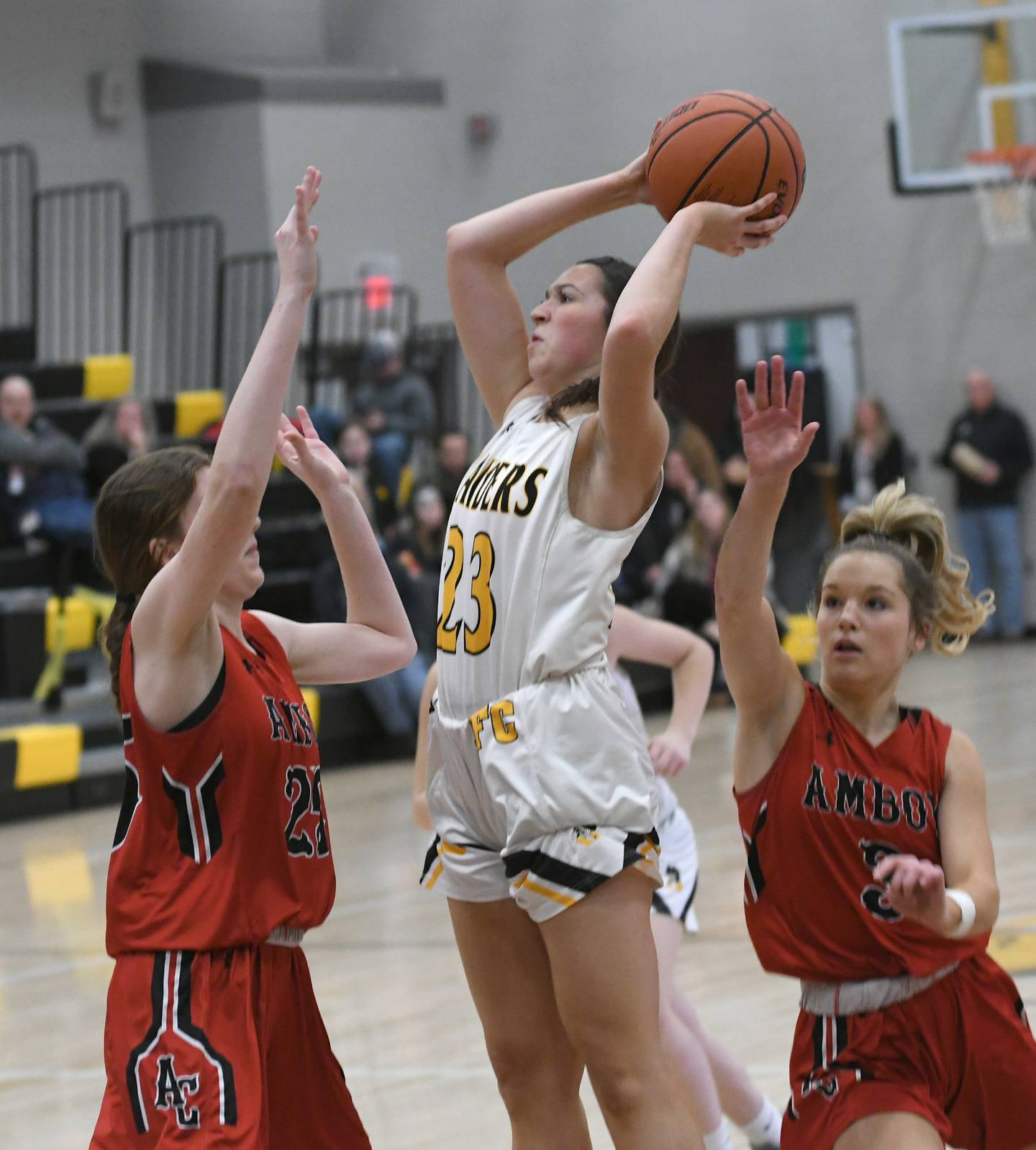 Ashton-Franklin Center's Brianna Gonnerman (middle) shoots as Amboy's Maeve Larson (left) and Elly Jones defend during a Feb. 7 game in Ashton.