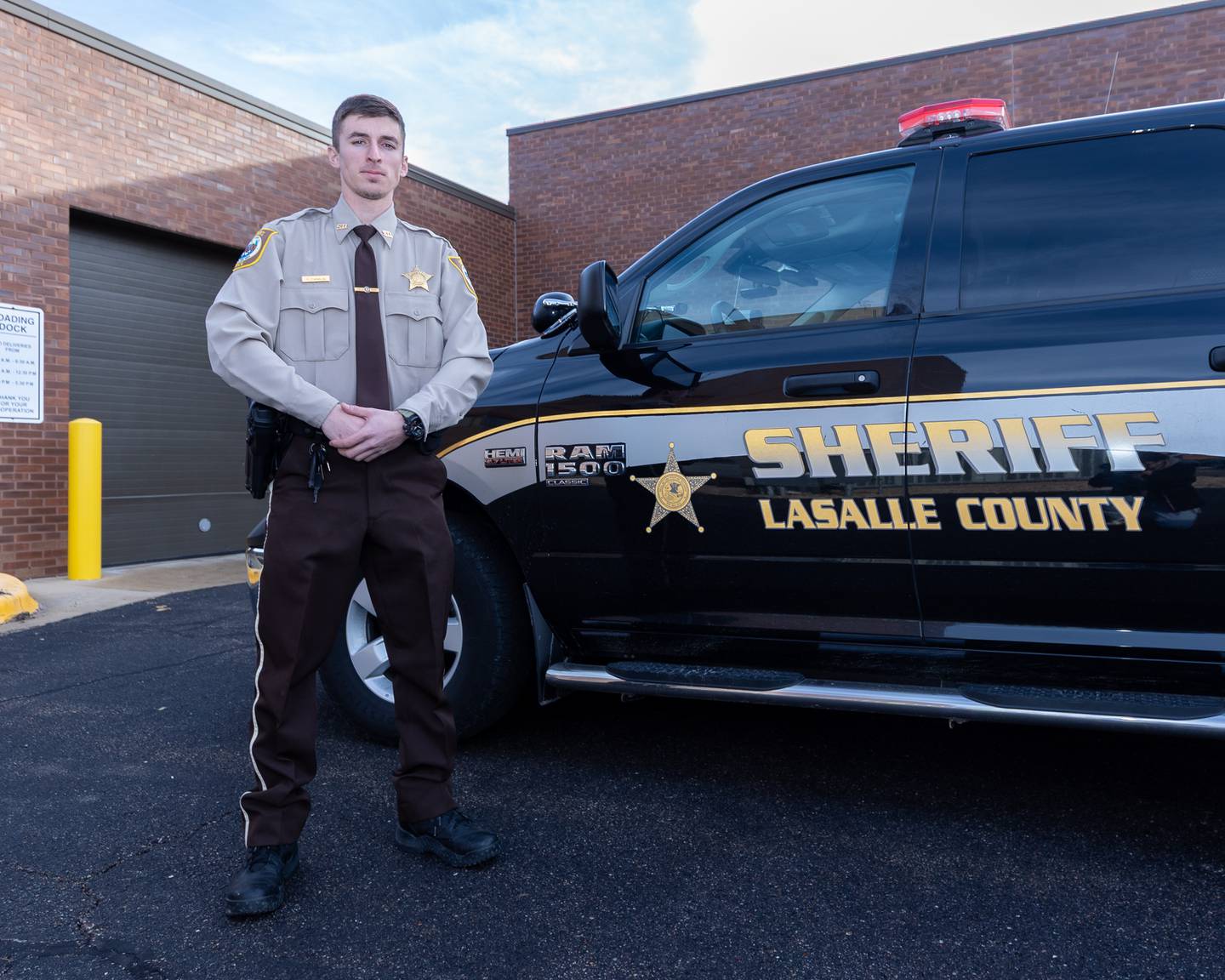 Newly graduated Deputy, Andrew Damron poses for portrait outside LaSalle County Sheriff Truck on Tuesday, December 23, 2025 at LaSalle County Correctional Sheriffs Office in Ottawa. Deputy Damron is one of the 6 newly hired to the agency this December.