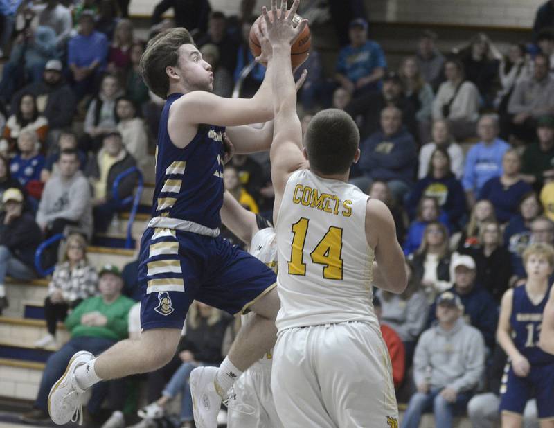 Marquette’s Tommy Durdan goes up and over Reed Custer’s Lucas Foote to score  in the first quarter of Wednesday's semifinal of the Marquette Christmas Tournament at Bader Gym in Ottawa.- 12/28/22