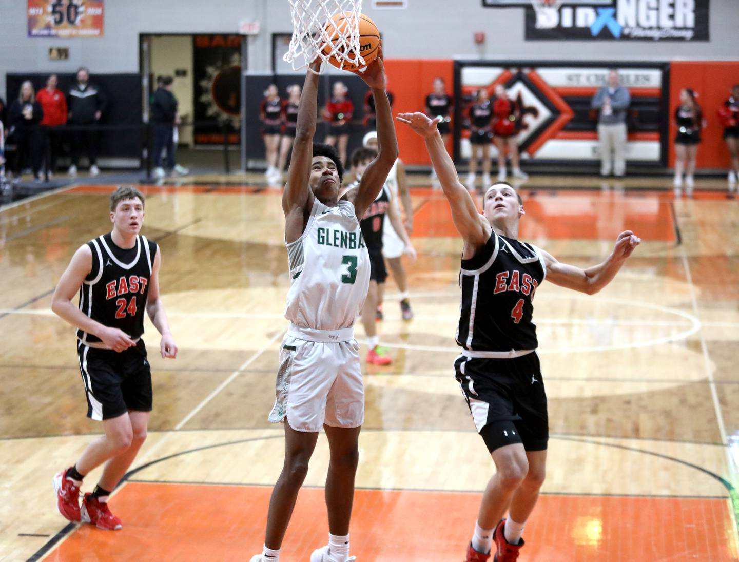 Glenbard West's TJ Williams goes up for a dunk past Glenbard East's Michael Nee during a Class 4A St. Charles East Sectional semifinal on Tuesday, March 4, 2025 in St. Charles.