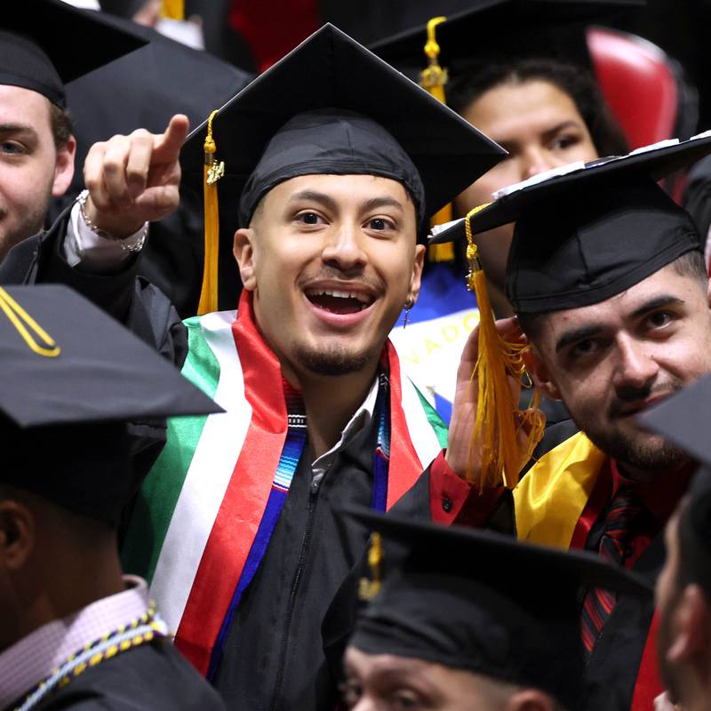 A Northern Illinois University candidate for graduation points out someone in the crowd during the first of two undergraduate commencement ceremonies Saturday, May 11, 2024, in the Convocation Center at NIU in DeKalb.