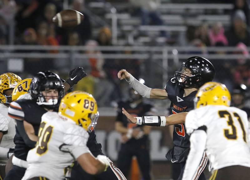 McHenry's Dayton Warren throws a pass as he is pressured by Jacobs' Charlie Glenn (left) and Blake Koziel (right) during a Fox Valley Conference football game on Friday, Oct. 18, 2024, at McCracken Field in McHenry.