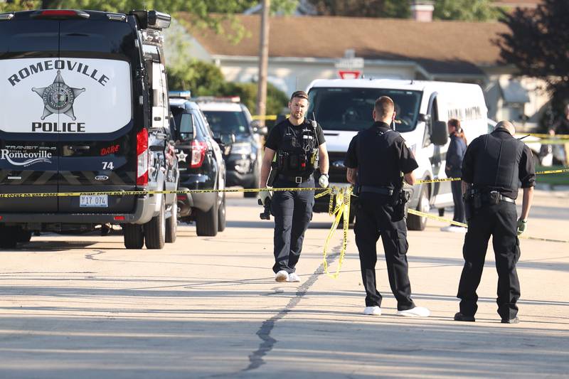 A police photographer leaves a home on the 500 block of Concord Avenue where police found the bodies of two adults and two children with gunshot wounds on Monday, Sept. 18, in Romeoville.