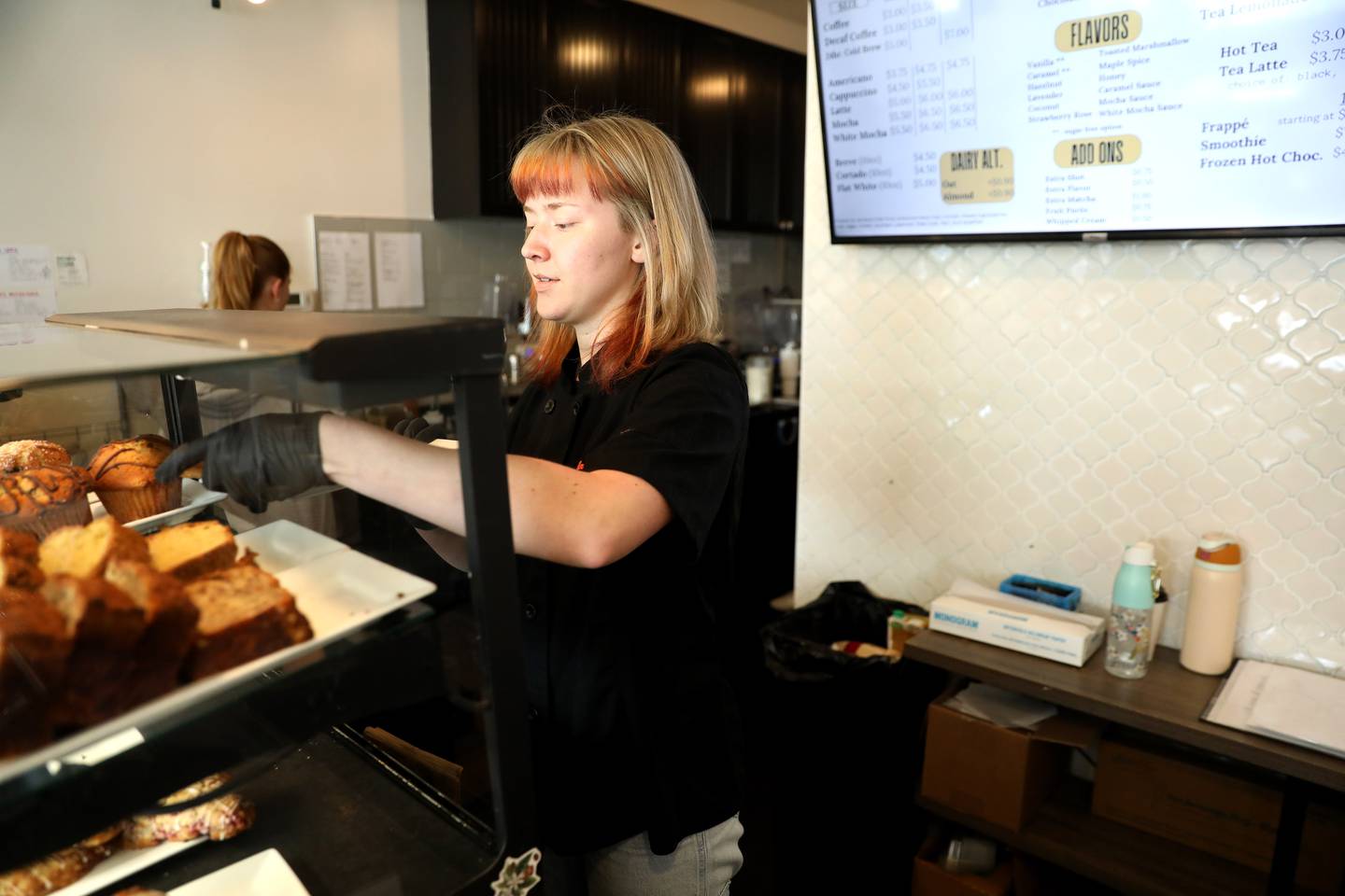 Baker Molly Fraser loads the bakery display at Corner Grind in Elburn. Fraser and Austin Dabbert (not pictured) of Wheaton joined the Corner Grind crew after both worked for Grahams 318 in Geneva, which closed in April.