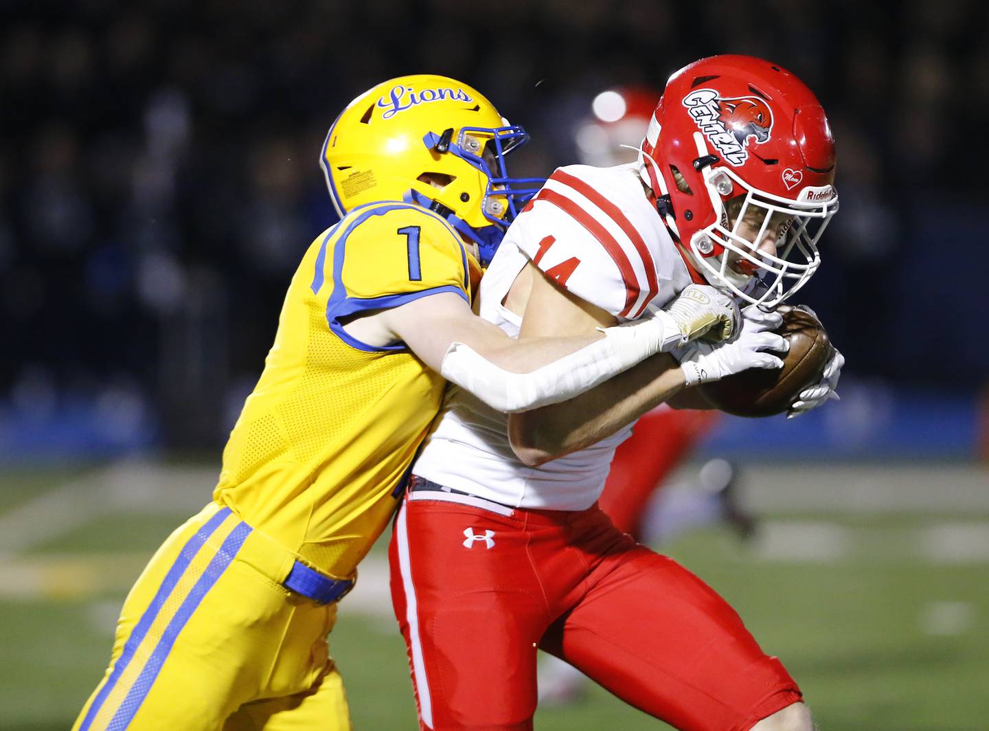 Lyons' Danny Montsesano (1) wraps up Naperville Central's Logan Devick (14) during a first round Class 8A varsity football playoff game between Lyons Township and Naperville Central on Friday, Oct. 28, 2022 in Western Springs, IL.