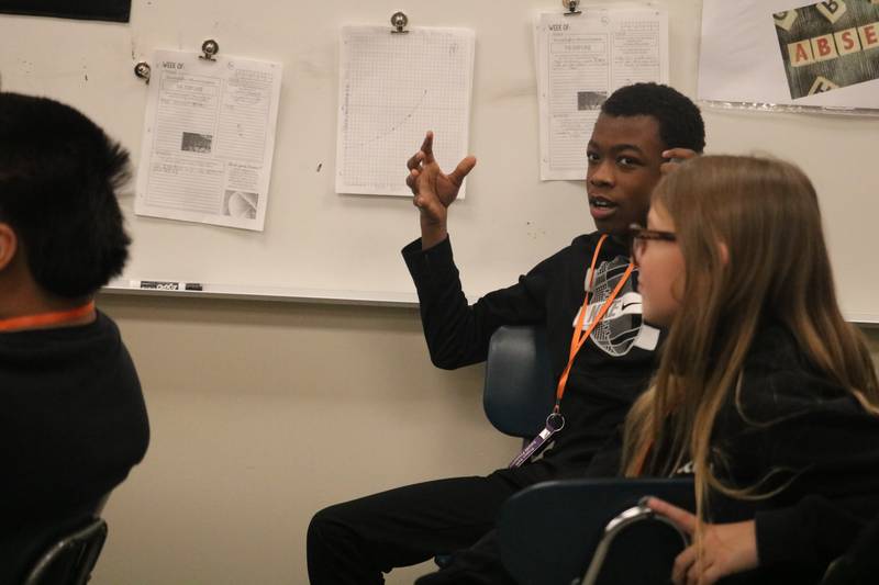 DeShawn Wallace (center) raises his hand to ask a question on Monday, Nov. 10, 2025, during a Veterans Day visit to a classroom at Clinton Rosette Middle School in DeKalb.