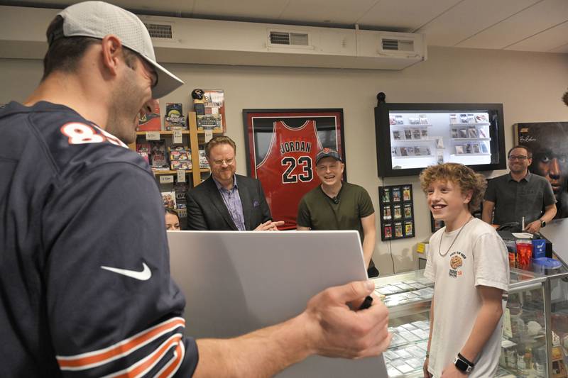 Jonah Davis, a 14-year-old heart patient from Downers Grove is surprised with tickets to a Chicago Bears game by Bears player Cole Kmet at a surprise party at Mark’s Card Shop in Downers Grove on Tuesday, Oct. 29, 2024.