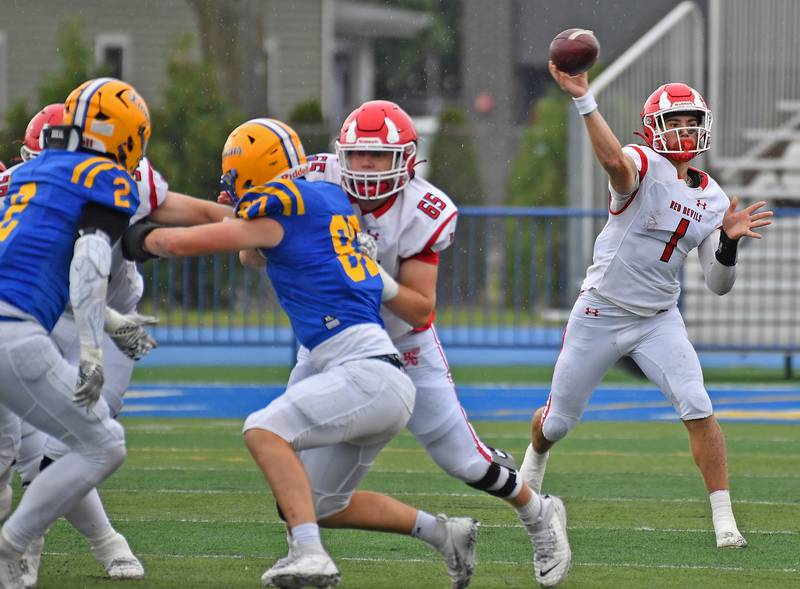 Hinsdale Central quarterback Riley Contreras (1) fires a pass from behind the block of lineman Liam Corrigan (65) during a game against Lyons Township on September 20, 2025 at Lyons Township High School in LaGrange.