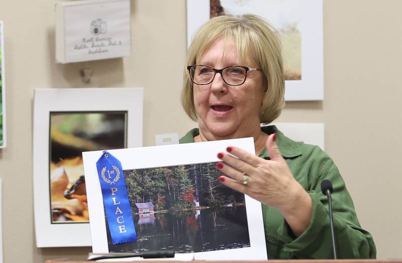 Tammy Zellers of Ottawa, holds her first place photo of early fall at the boat house taken in New Hampshire during the Starved Rock Photography Show awards on Saturday, Jan. 3, 2026 at the Starved Rock Visitors Center.