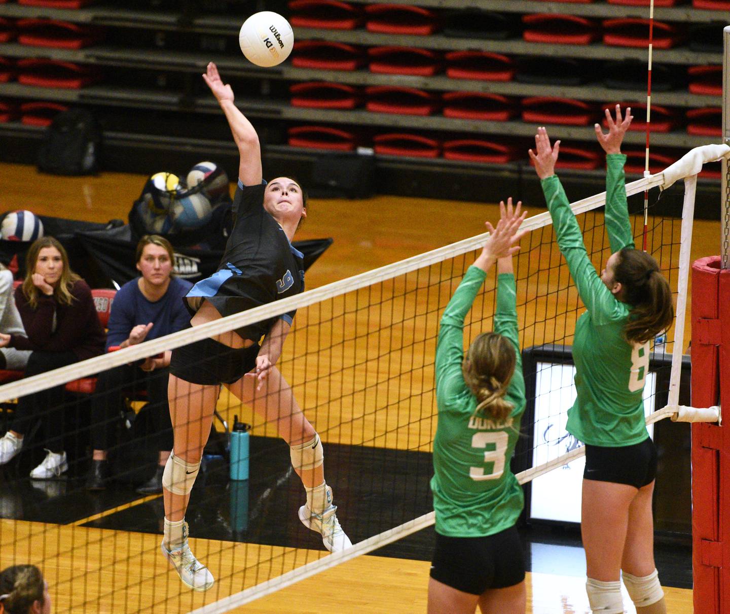 Willowbrook's Calli Kennyy (9) hits into the York blockers during Monday's Proviso West Class 4A girls sectional volleyball match in Hillside.