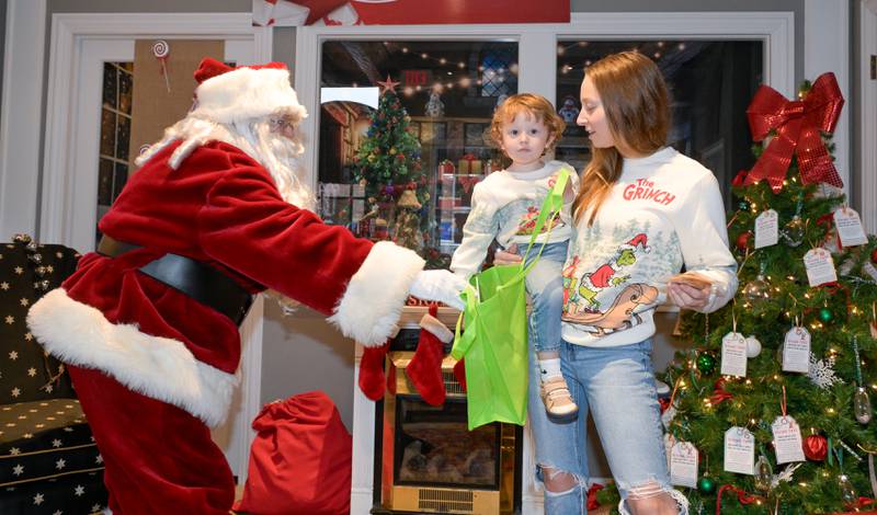 Santa gives a gift to AJ Dubsky, 2 during a visit with Santa at the Geneva Visitor Center on Saturday, Dec 20, 2025 in Geneva.