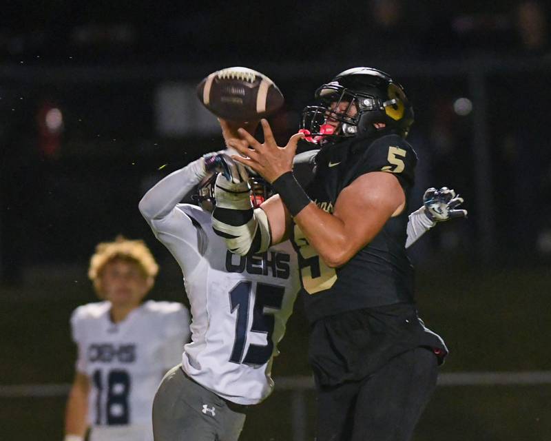 Sycamore's Kyle Prebil (5) catches a long pass during the game while being defended by Oswego East's Jamari Mckay (15) on Friday Sept. 6, 2024, held at Sycamore High School.