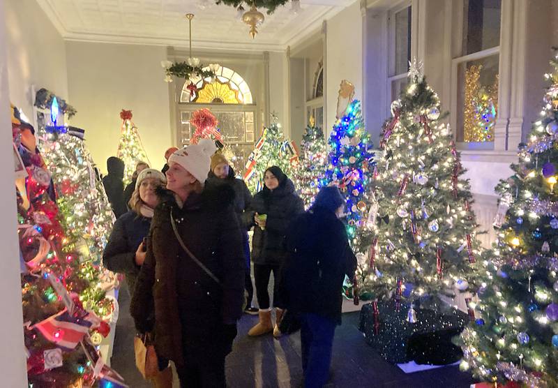 People look at the decorated Christmas trees during the Christmas Tree Walk inside the Woodstock Opera House during the Lighting of the Square Friday, Nov. 29, 2024, in Woodstock. The annual holiday season event featured brass music, caroling, free doughnuts and cider, food trucks, festive selfie stations and shopping.