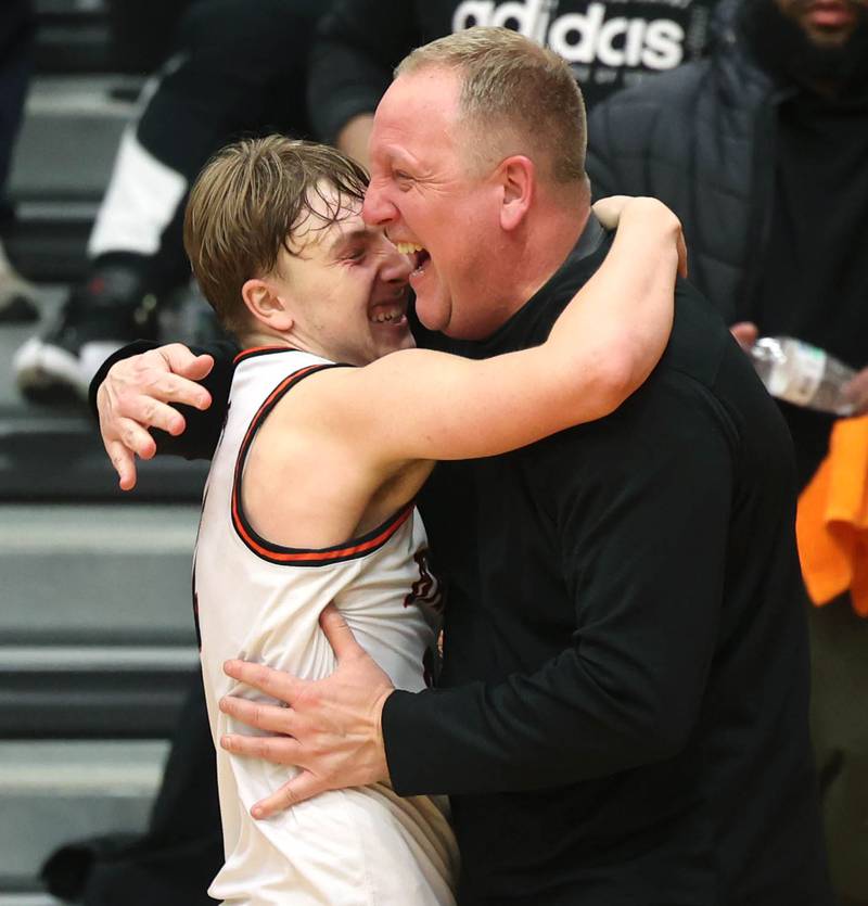 DeKalb Head Coach Mike Reynolds hugs his son Sean after their team beat Waubonsie Valley Friday, Feb. 21, 2025, at DeKalb High School.