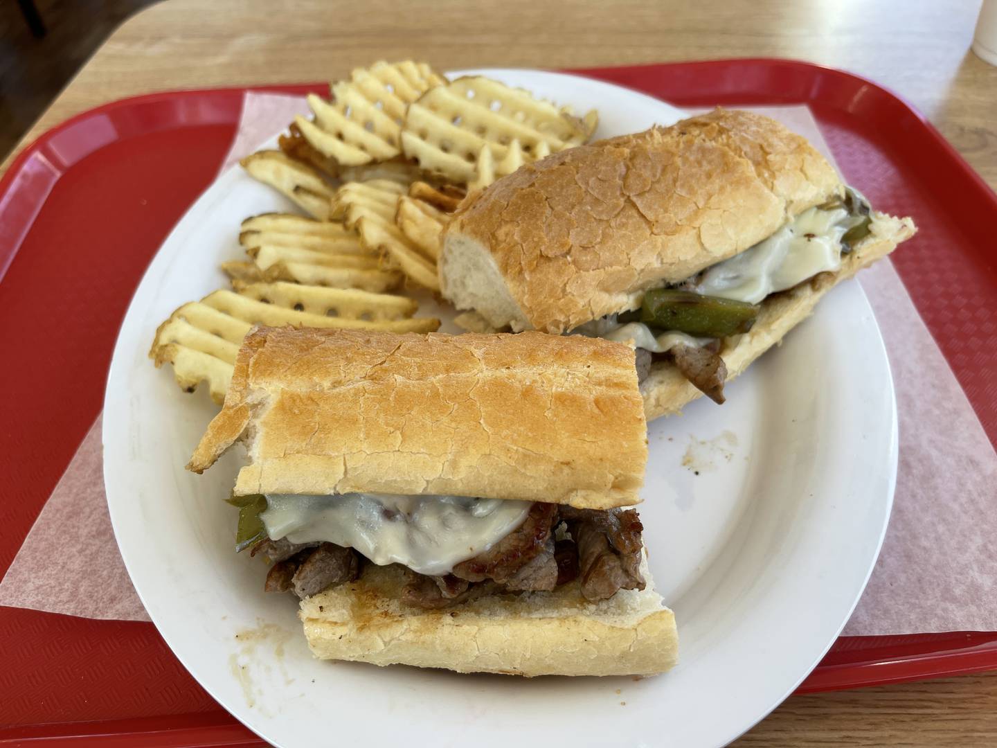 The Philly Steak, with peppers and mozzarella stuffed into a french bread, paired with waffle fries.