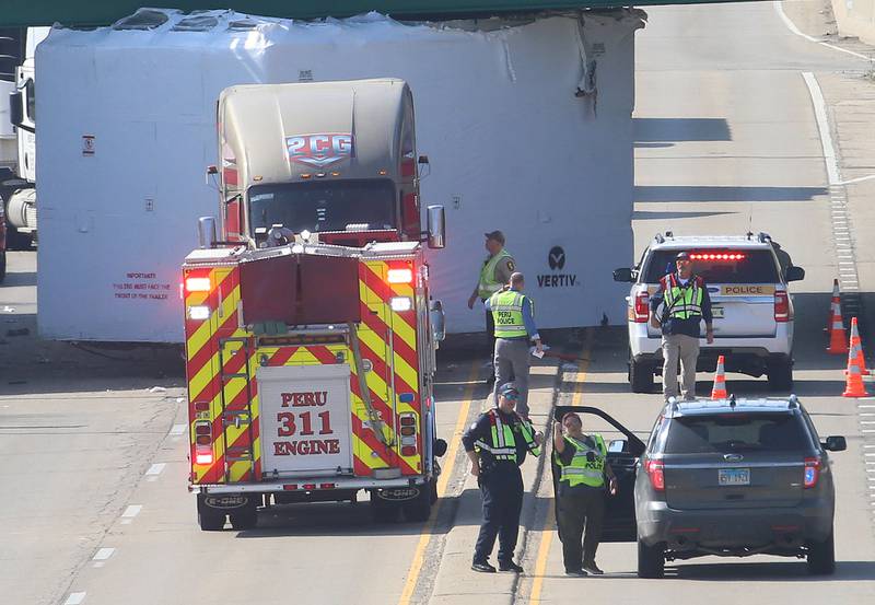 Peru firefighters work the scene of a semi truck that struck the U.S. Route 6 overpass on Monday, March 30, 2026 in Peru. Traffic was closed in both northbound and southbound directions on Illinios Route 251. Peru Police and Fire were on the scene. The incident happened shortly before 10a.m.