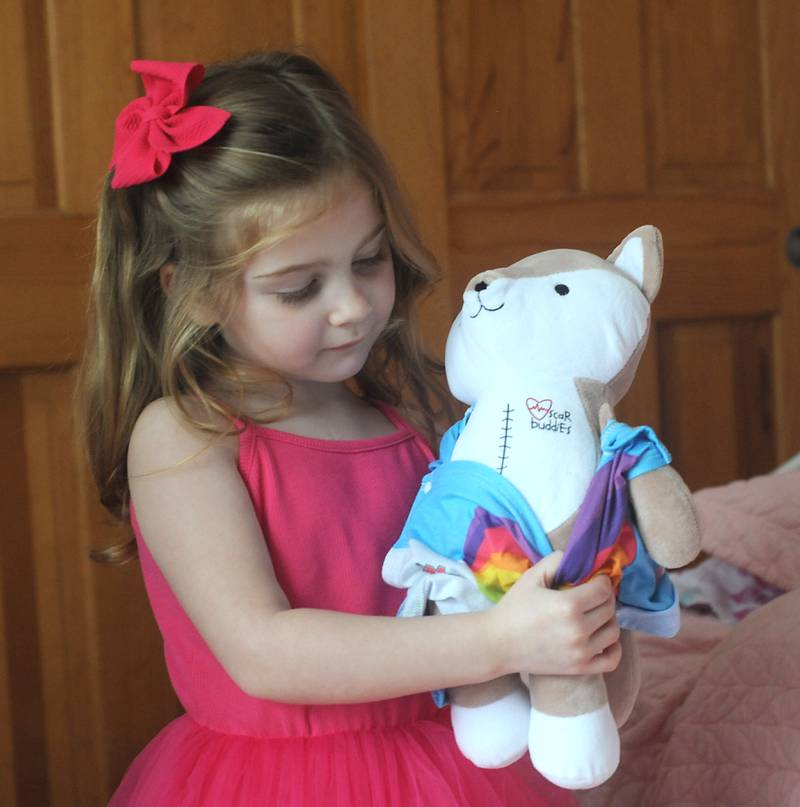 Everly Backe, 4, who has had multiple open heart surgeries to correct congenital heart defects, plays with a doll that has a scar like hers on Friday, Feb. 11, 2022.