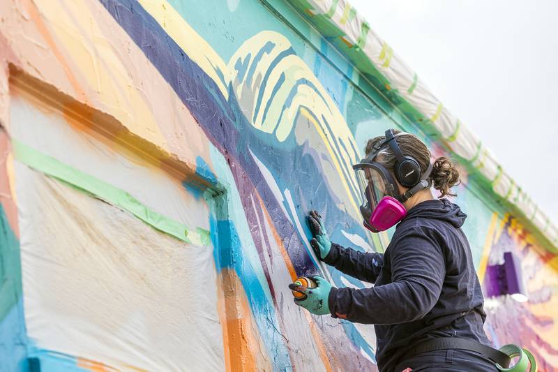 Dixon based muralist Anne Hermes works on a piece Saturday, Nov. 1, 2025, on the Blackhawk Hills Regional Council building in Rock Falls. The hummingbird design was chosen to reflect the council’s motivation towards nature conservancy and to appeal to a large audience.