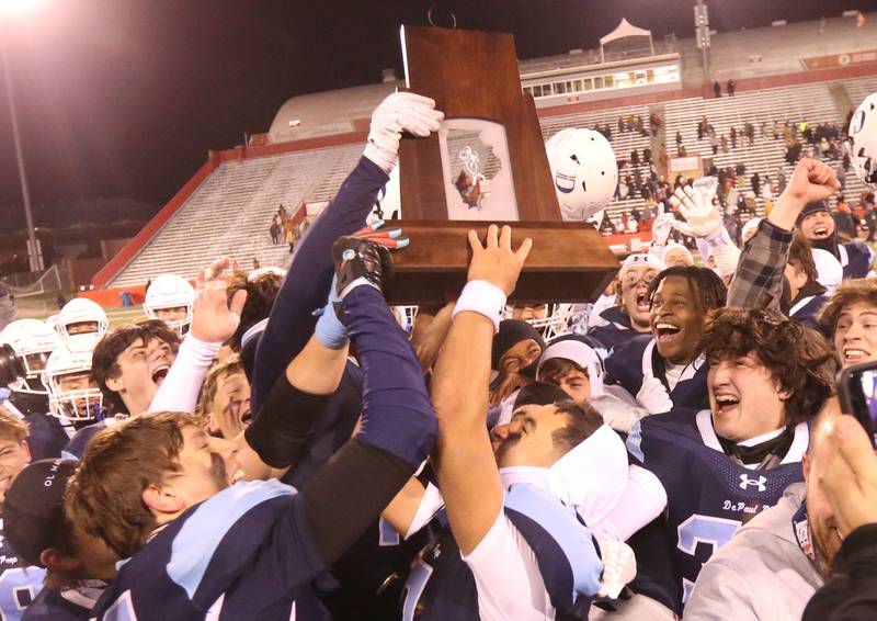 Members of the DePaul football team hoist  the Class 4A State football championship trophy on Friday, Nov. 29, 2024 at Hancock Stadium in Normal.