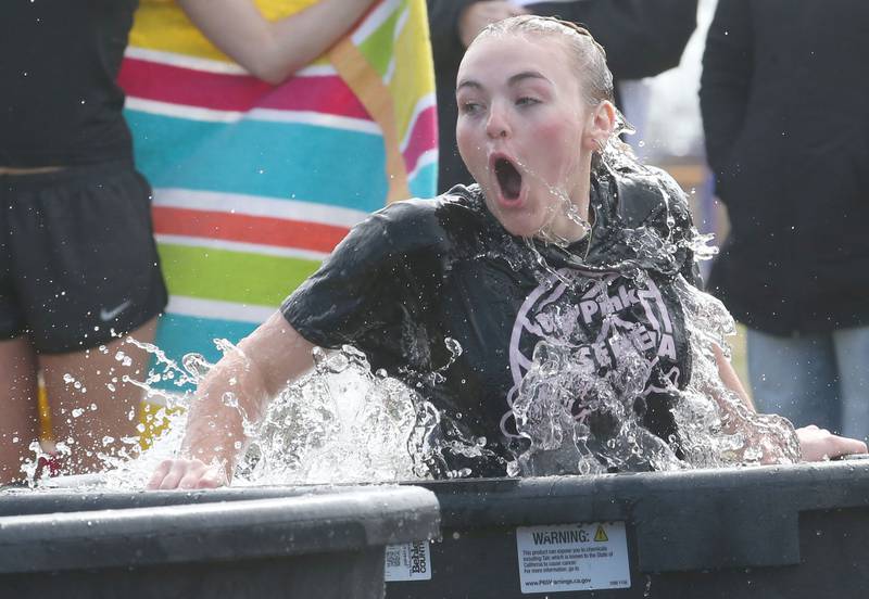 Brinley Glade hops into a bucket of cold water during the Polar Plunge for Special Olympics on Friday, March 21, 2025 at Serena High School.