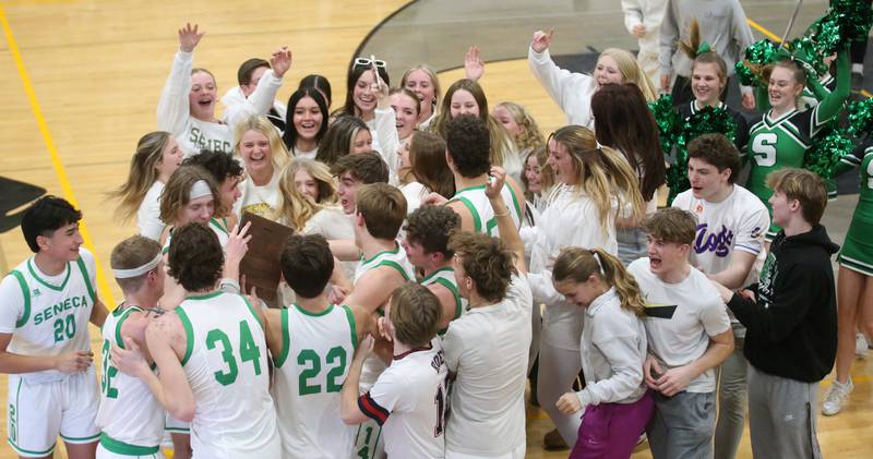 Members of the Seneca boys basketball team, super fans and cheerleaders celebrate after winning the Tri-County Conference championship over Marquette on Friday, Jan. 31, 2025 at Putnam County High School.
