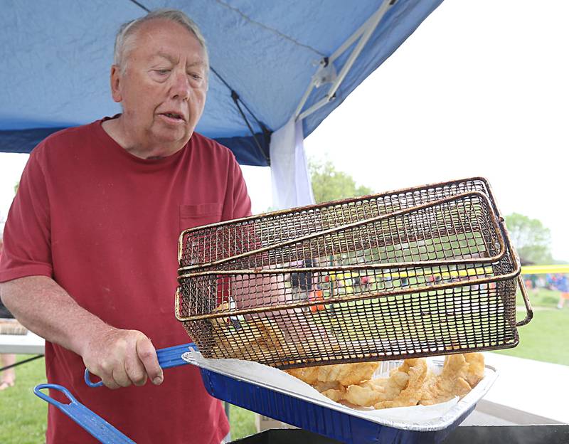 Dale Subkowiak of Peru, fries up fried fish during the twenty-third annual Kids Fishing Expo on Saturday, May 13, 2023 at Baker Lake in Peru. Catfish, bluegill and croppie were cooked for children and adults to sample.