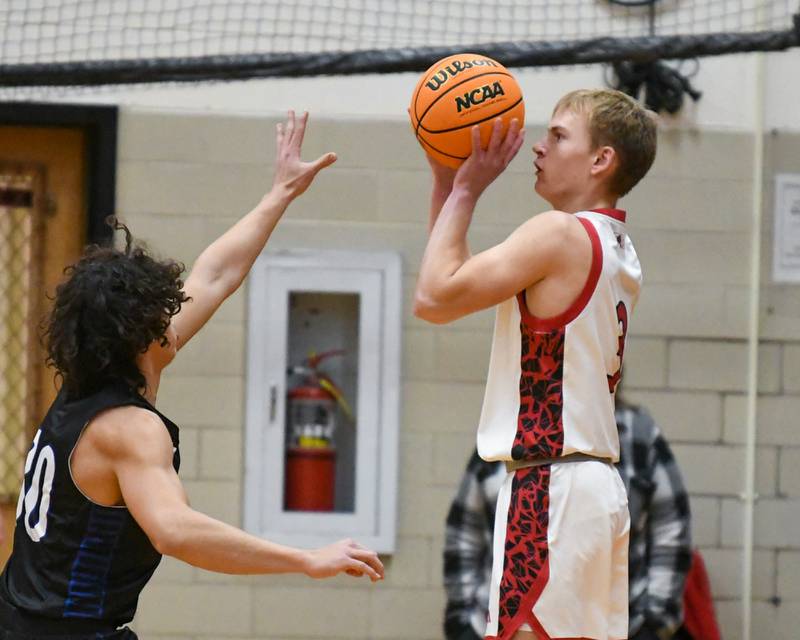 Glenbard East's Danny Snyder, right, makes a three-point basket while being defended by Riverside Brookfield's Liam Enright (30) during the game on Friday Dec. 19, 2025, held at Glenbard East High School.