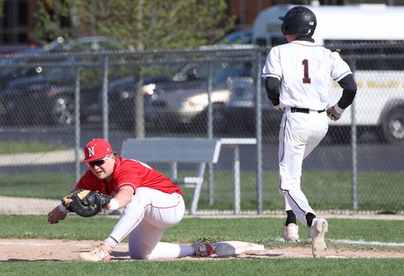 Naperville Central's Troy Kashul stretches for the ball and just gets DeKalb's Jackson Kees at first during their game Tuesday, April 30, 2024, at DeKalb High School.