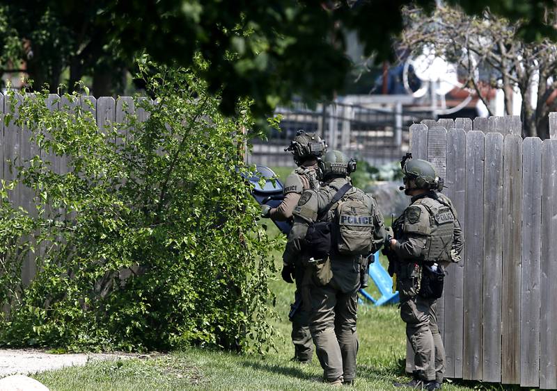 Law enforcement from area departments surround a home on Thursday, June 5, 2025, in the area of Venice Avenue and Court Street in McHenry.