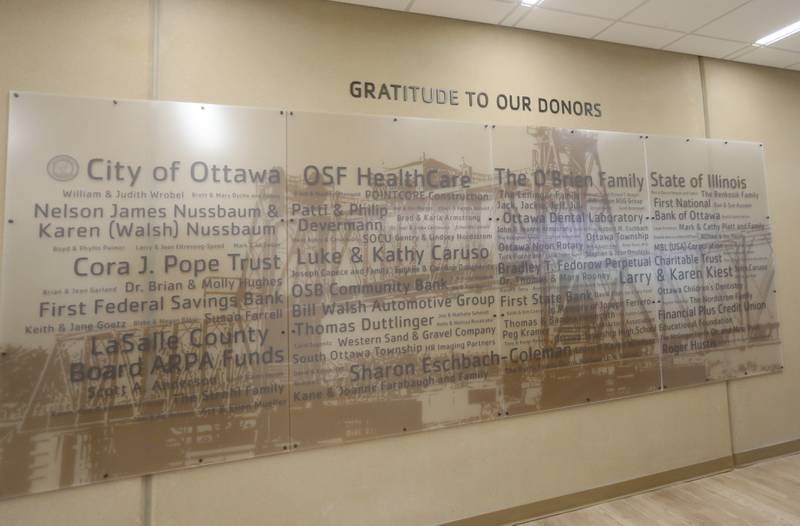 A donor wall with the background of the Ottawa Railroad Bridge is one of the first things the public sees when entering the new YMCA on Monday, May 6, 2024 in Ottawa.