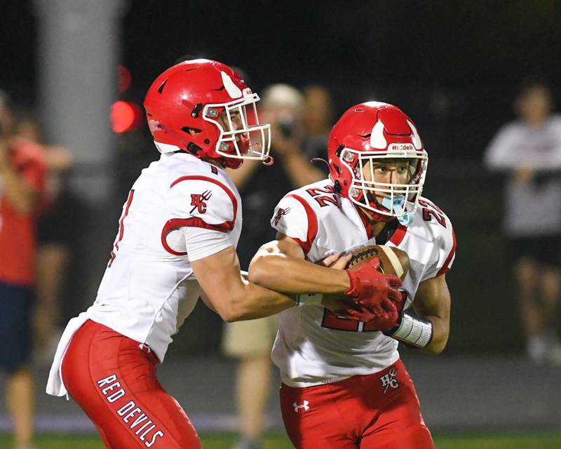 Hinsdale Central's Riley Contreras, left, hands the ball off to teammate Dominic Tresslar during the game on Friday Sept. 12, 2025, while traveling to take on Downers Grove North High School.