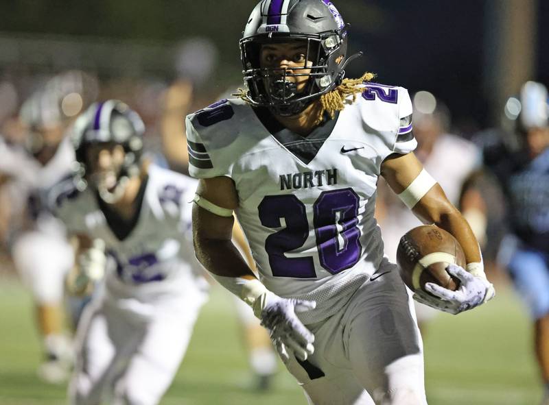 Downers Grove North’s Noah Battle (20) runs the ball against Downers Grove South during the boys varsity football game on Friday, Sept. 1, 2023.