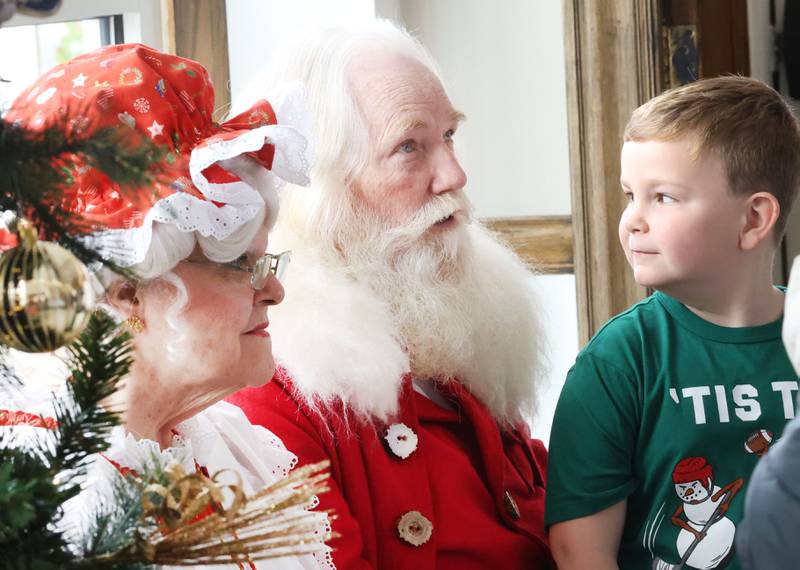 Roman Pearson of Princeton looks at Santa and Mrs. Claus during the annual Christmas Walk on Saturday, Nov. 22, 2025 outside the Clark House in Princeton.