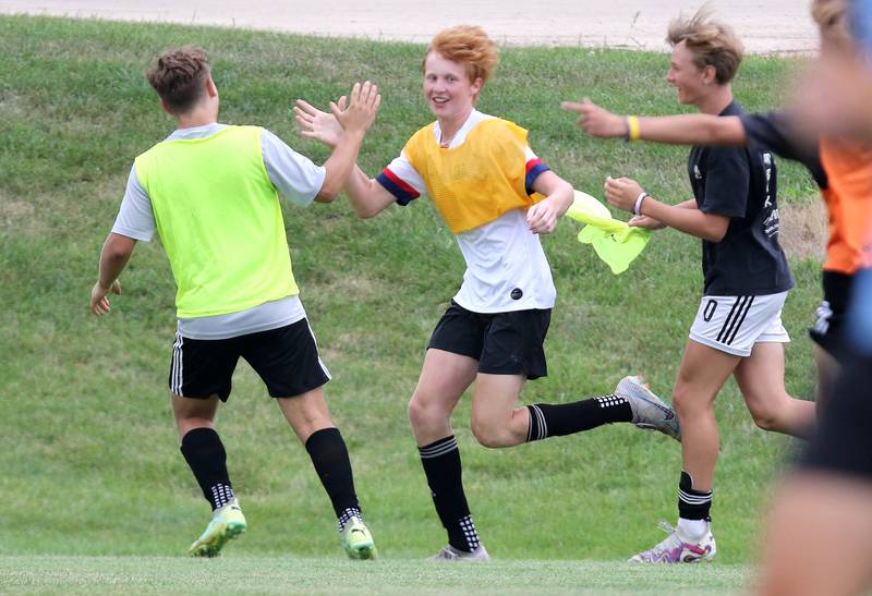 Sycamore’s Jameson Carl (middle) celebrates with teammates after scoring a goal in a scrimmage at practice Wednesday, August 9, 2023, at Sycamore High School.