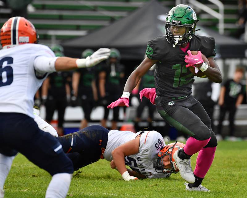 Glenbard West's Teyion Oriental (right) escapees a tackle by Naperville North's Ben Mittenthal (55) during an IHSA Class 8A playoff game on Oct. 28, 2023 at Glenbard West High School in Glen Ellyn.