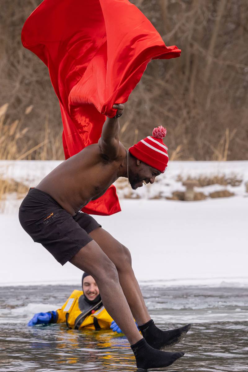 Make-A-Wish staff member Jerry Darko leaps off of the dock with a superman cape trailing behind at the Make-A-Wish Illinois Penguin Plunge on  January 31, 2026 at Skydive Chicago.