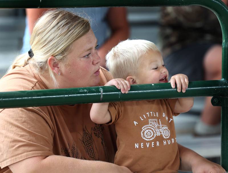 Cannon Wiesbrook, 2, from Lisbon, gets a boost from his mom Blair so he can watch the pig judging Wednesday, Sept. 3, 2025, on opening day of the Sandwich Fair.